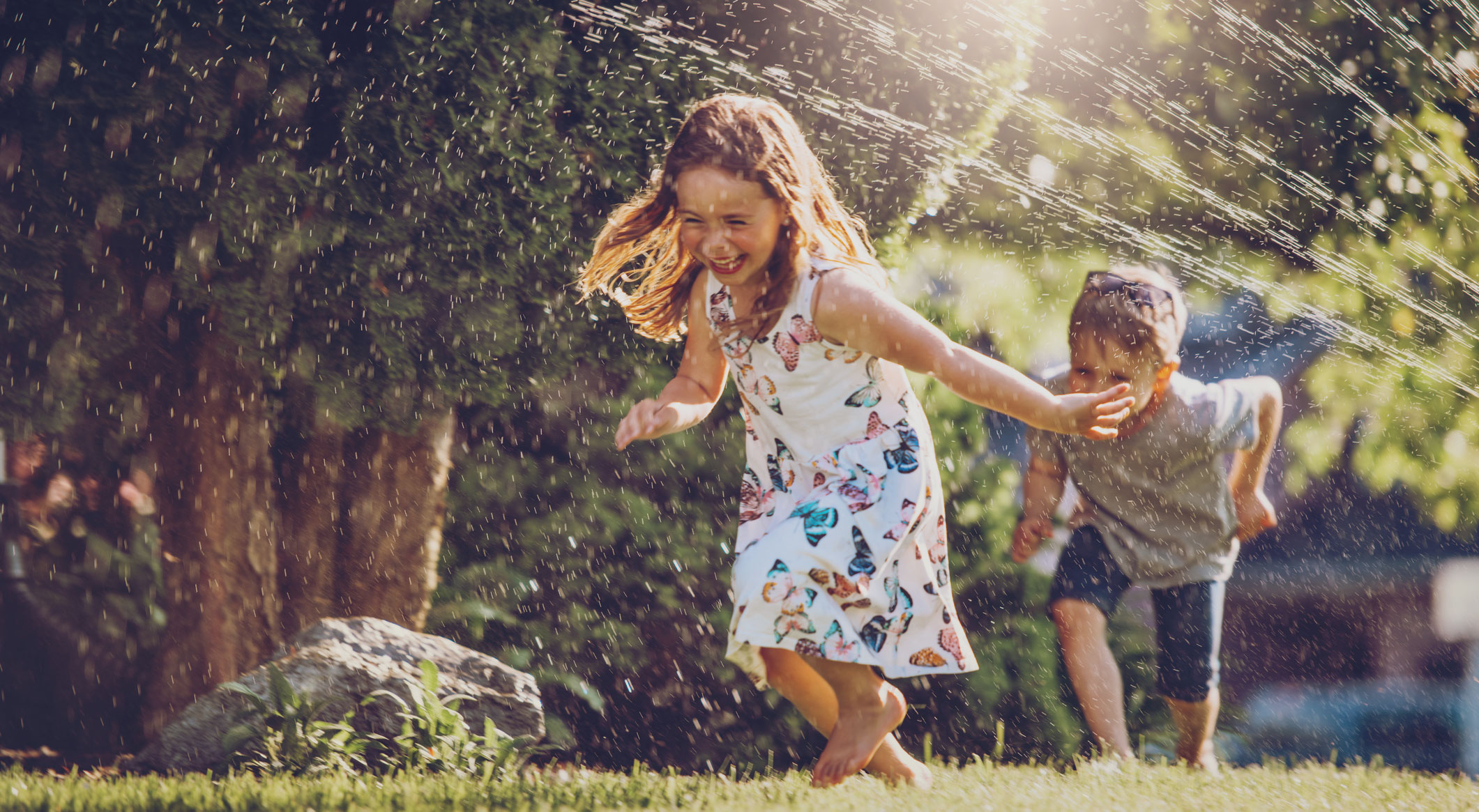 Two kids running in a garden